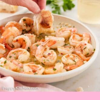 Pinterest graphic of torn bread dipped into a plate of shrimp scampi.