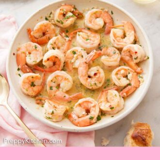Pinterest graphic of an overhead view of a plate of shrimp scampi with a glass of wine and torn bread beside it.