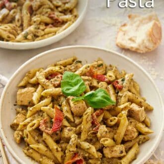 Pinterest graphic of two bowls of chicken pesto pasta with one in the front, with some bread in the background.