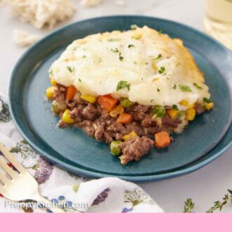 Pinterest graphic of a plate of shepherd's pie with some torn bread and a glass of wine in the back.