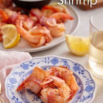 Pinterest graphic of three bacon wrapped shrimp on a plate with a platter with dip on at the back.