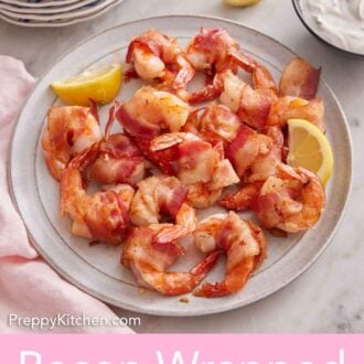 Pinterest graphic of a plate of bacon wrapped shrimp with lemon wedges.