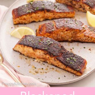 Pinterest graphic of a platter of blackened salmon with lemon wedges.