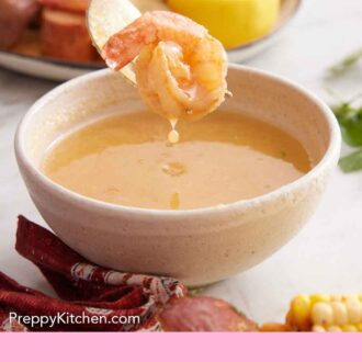 Pinterest graphic of a bowl of butter mixture dip with a shrimp lifted up from it.