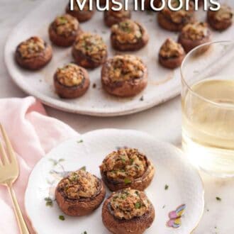 Pinterest graphic of a plate with three stuffed mushrooms by a glass of wine and a platter of mushrooms.