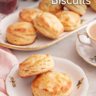 Pinterest graphic of a plate with two buttermilk biscuits with a platter in the back along with a cup of coffee.
