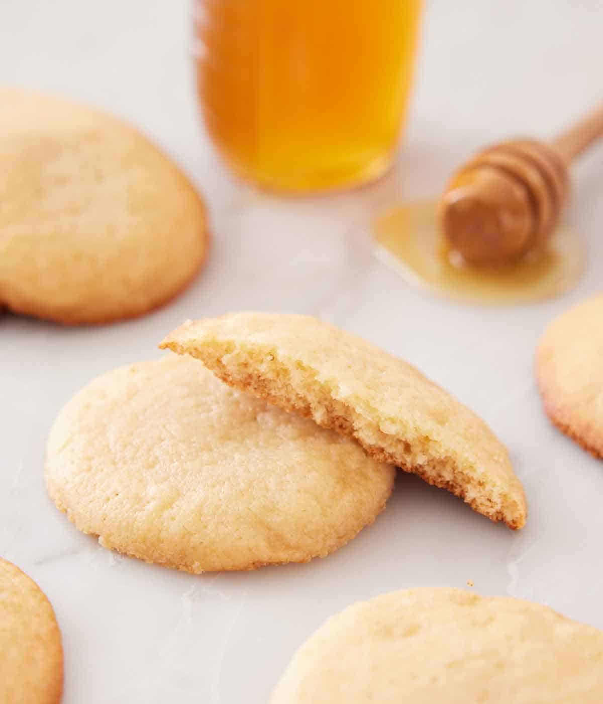 A honey cookie with a half cookie stack on it, showing the inside texture.