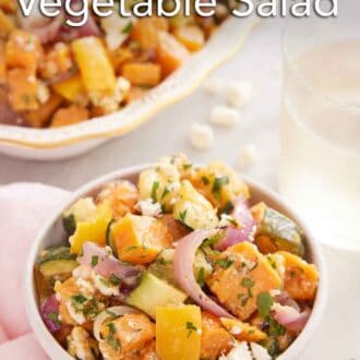 Pinterest graphic of a bowl of roasted vegetable salad with a glass of wine and platter of more veggies in the background.