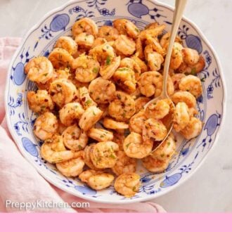Pinterest graphic of an overhead view of a large plate of sautéed shrimp with a spoon tucked inside.