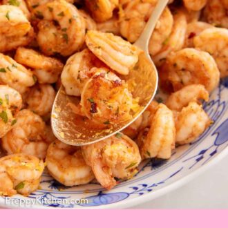 Pinterest graphic of a spoonful of sautéed shrimp in a serving platter.