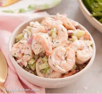 Pinterest graphic of a white bowl with shrimp salad.