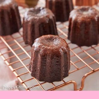 Pinterest graphic of canelés on a wire cooling rack. Two molds in the background.