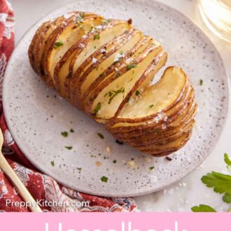 Pinterest graphic of a plate with a hasselback potato with salt and parsley sprinkled on top.