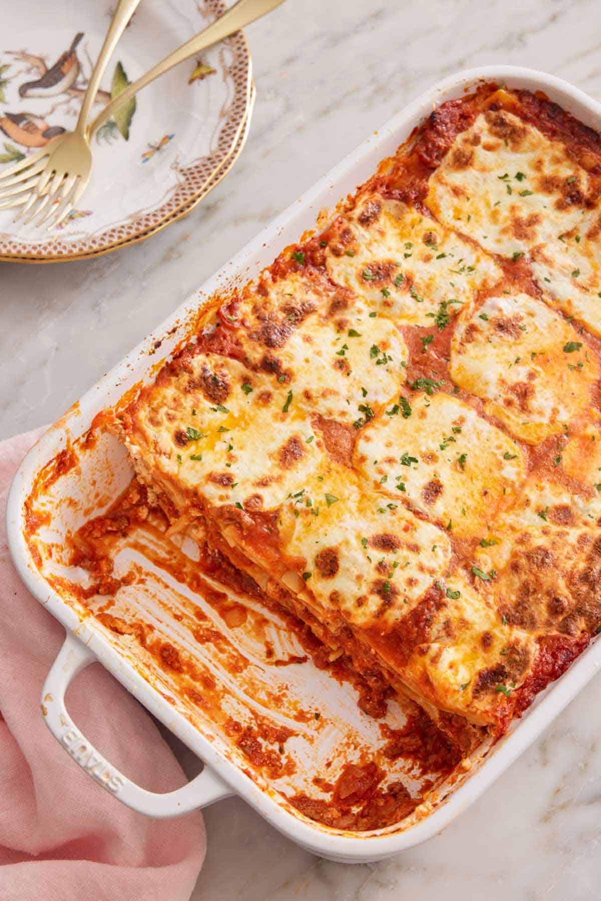 Overhead view of a baking dish with lasagna with a fifth removed.