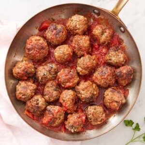 Overhead view of a skillet of meatballs tossed in sauce.
