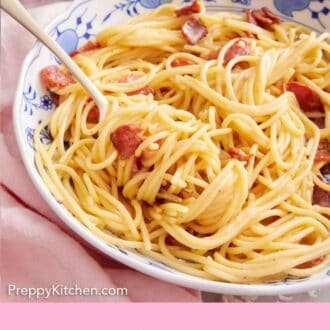 Pinterest graphic of a plate of pasta carbonara with a fork tucked in.