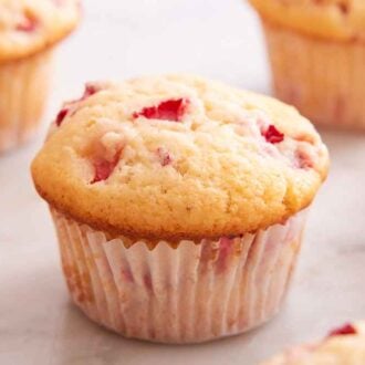 Multiple strawberry muffins with one in focus in the middle of the frame.