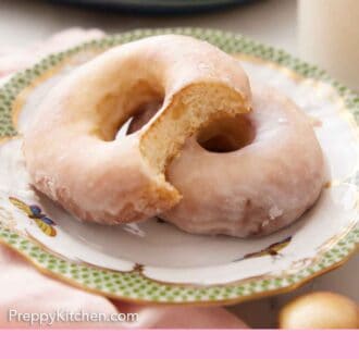 Pinterest graphic of a plate with a two air fryer donut with one stacked on top with a bite taken out of it.