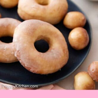 Pinterest graphic of a dark platter with multiple air fryer donuts and donut holes on them.