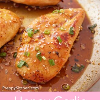 Pinterest graphic of a close up view of a honey garlic chicken breast in a skillet with green onions and sesame seeds on top.