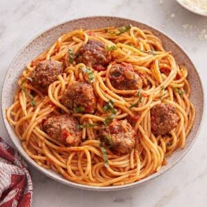 Overhead view of a plate of spaghetti and meatballs with a fork beside it.