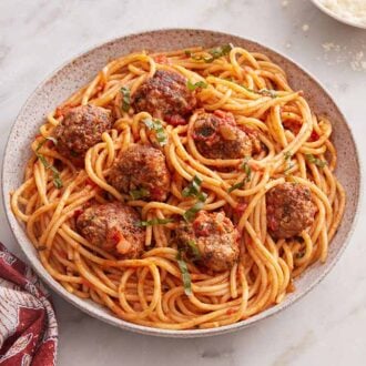 Overhead view of a plate of spaghetti and meatballs with a fork beside it.