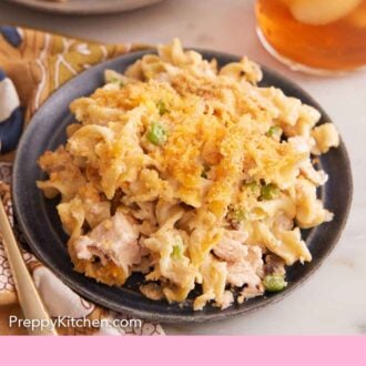 Pinterest graphic of two plates of tuna casserole, with one in front, with a glass of iced drink on the side.