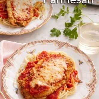 Pinterest graphic of two plates of air fryer chicken parmesan over spaghetti noodles with a glass of wine and parsley in between the plates.