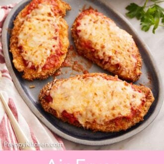 Pinterest graphic of a platter with three air fryer chicken parmesan. A bowl of spaghetti noodles in the background.