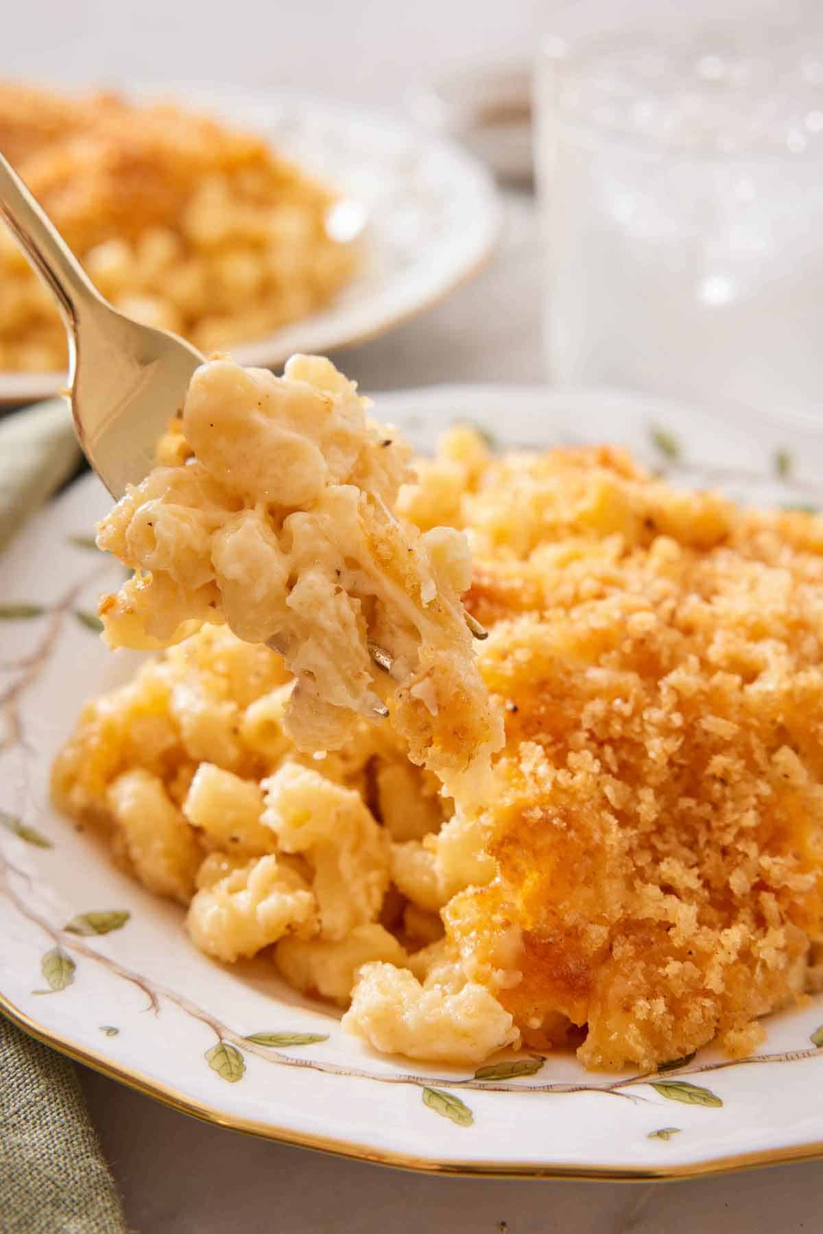 A forkful of baked mac and cheese lifted off a plate.