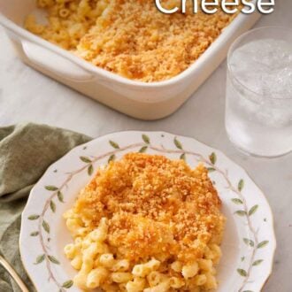 Pinterest graphic of a plate of baked mac and cheese with a glass of water and baking dish in the background.