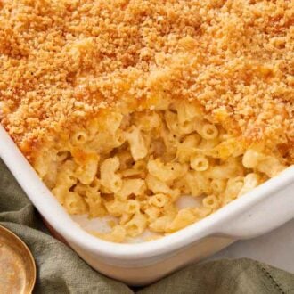 A white baking dish of baked mac and cheese with a serving taken out.
