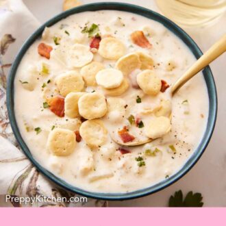 Pinterest graphic of a bowl of clam chowder with crackers on top with a glass of wine in the back.