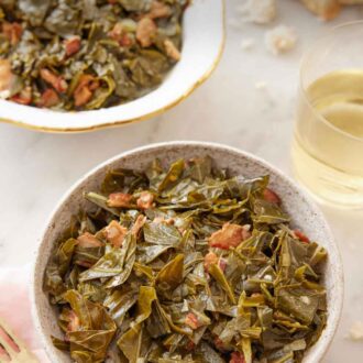 Pinterest graphic of a bowl of collard greens with a glass of wine and a serving platter in the background.