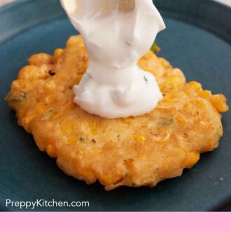 Pinterest graphic of sauce spooned on top of a crispy corn fritter on a plate.