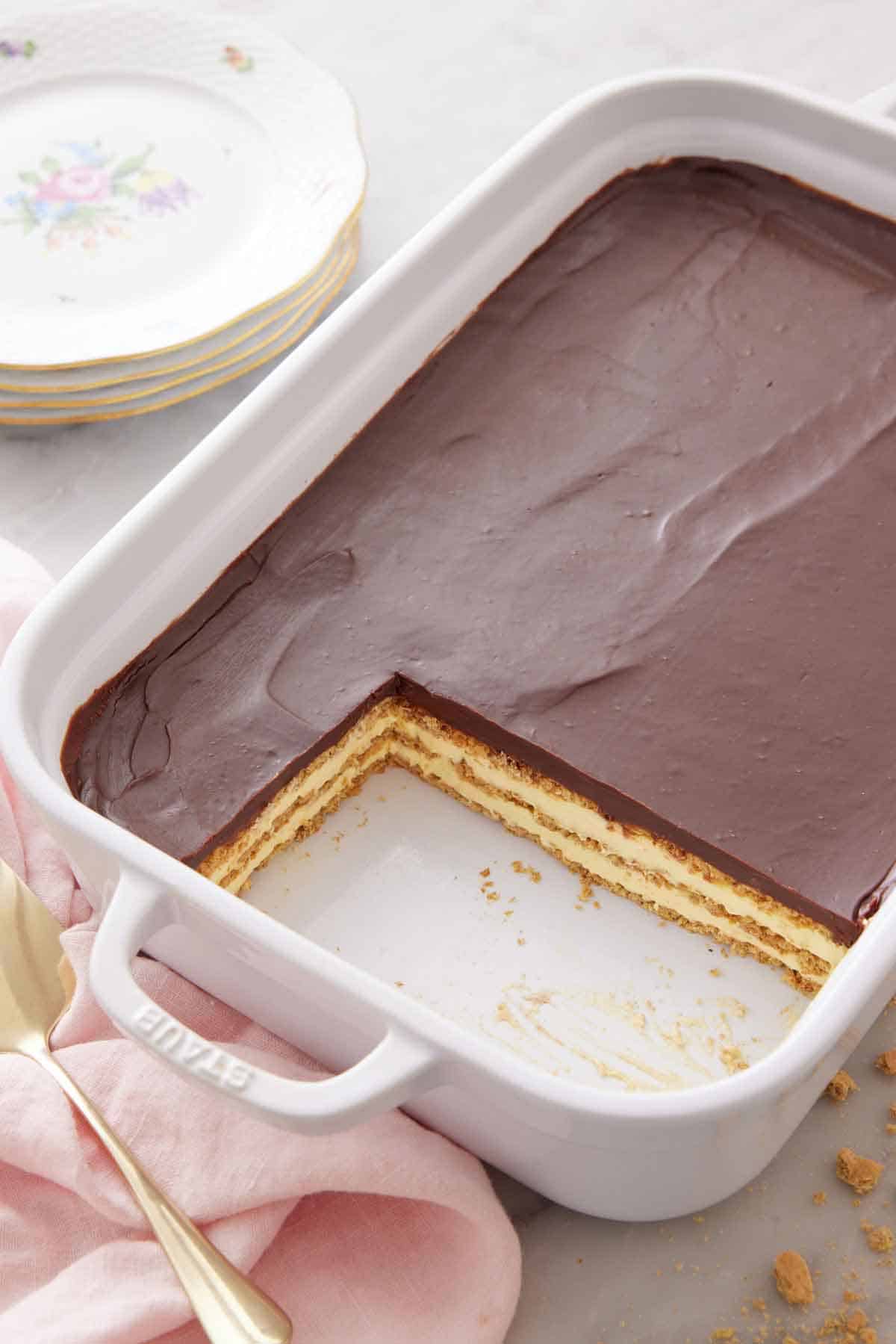 An angled view of an éclair cake in a baking dish with two slices cut out.