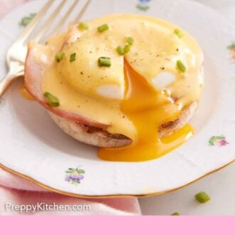 Pinterest graphic of a plate with eggs benedict topped with sauce, cut open with the yolk running out.