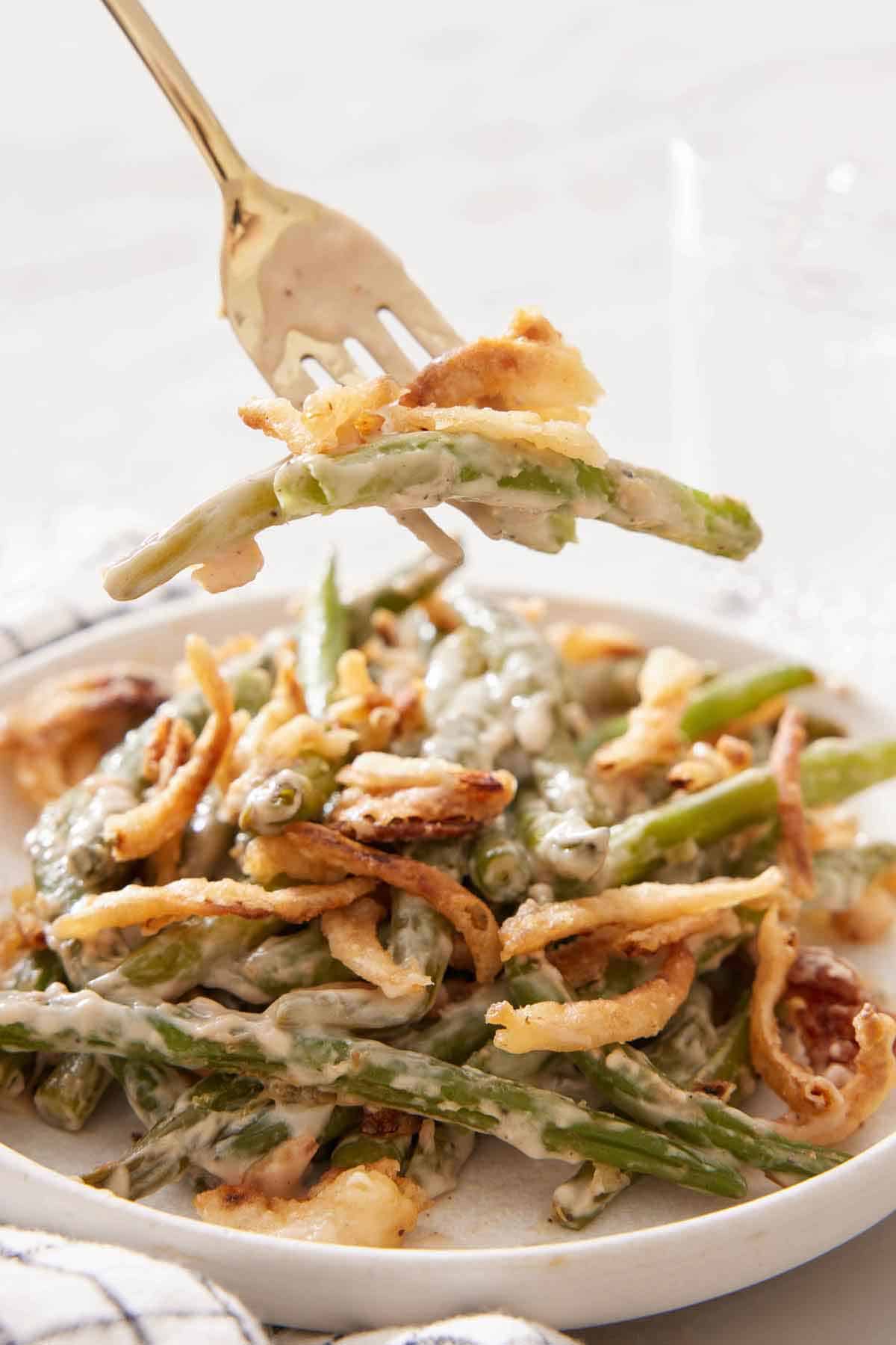 A forkful of green bean casserole lifted from a plate.