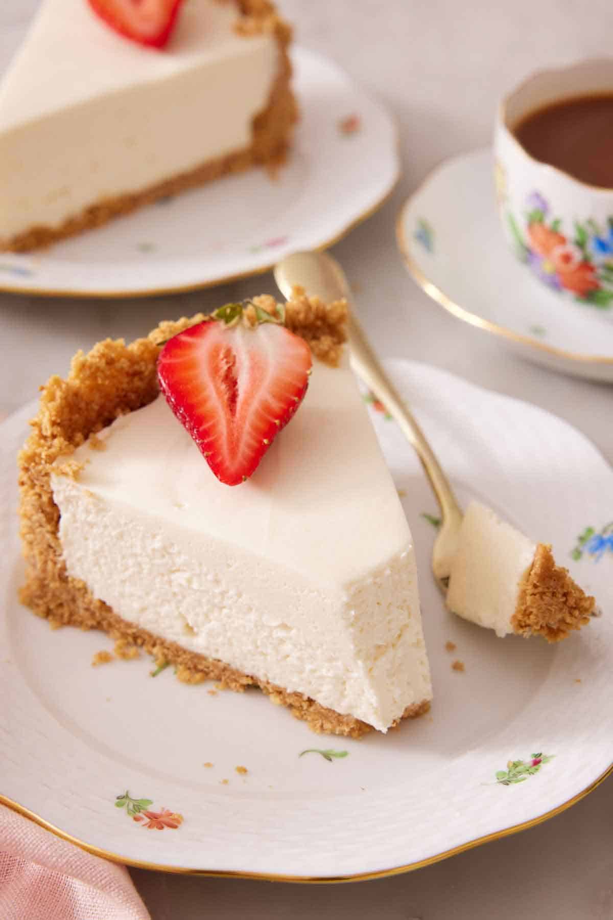 A slice of no bake cheesecake with the tip scooped off on a fork beside the slice.