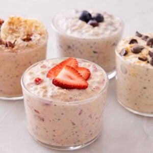 Four jars of overnight oats all topped with different toppings.
