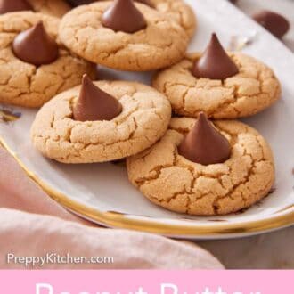 Pinterest graphic of a platter of peanut butter blossoms with chocolate chips scattered in the background.