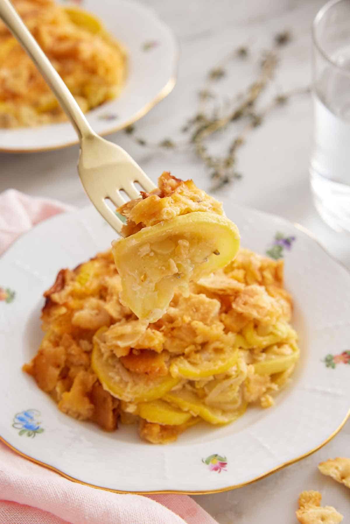A forkful of squash casserole lifted from a plate.