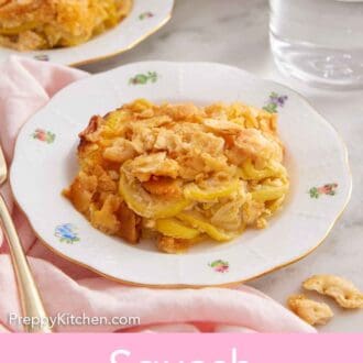 Pinterest graphic of a plate of squash casserole with a glass of water and second plate in the background.