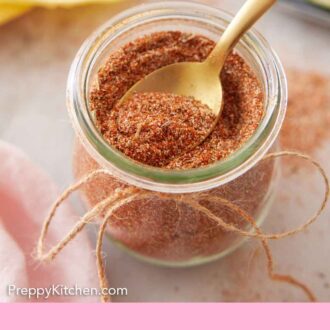Pinterest graphic of an overhead view of a spoon scooping out taco seasoning from a jar.