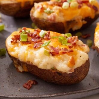 A platter of twice-baked potatoes topped with green onions and diced bacon.