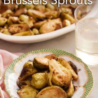 Pinterest graphic of a bowl of air fryer Brussels sprouts with a drink and platter of more sprouts in the background.