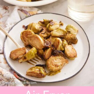 Pinterest graphic of a plate of air fryer Brussels sprouts with a fork with a platter and drink in the background.