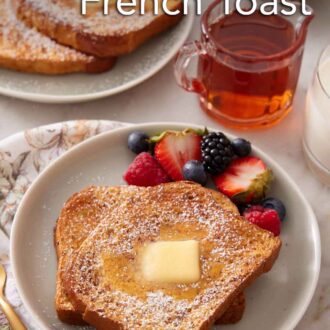 Pinterest graphic of a plate of air fryer french toast with powdered sugar, butter and syrup on top with berries on the side. A small vessel of syrup and another plated serving in the background.
