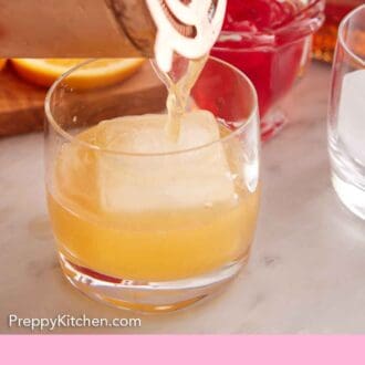 Pinterest graphic of an Amaretto Sour strained into a glass with an ice cube.
