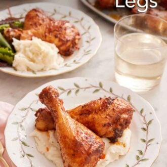 Pinterest graphic of a plate with two baked chicken legs over mashed potatoes with a glass of wine and another plated serving in the background.